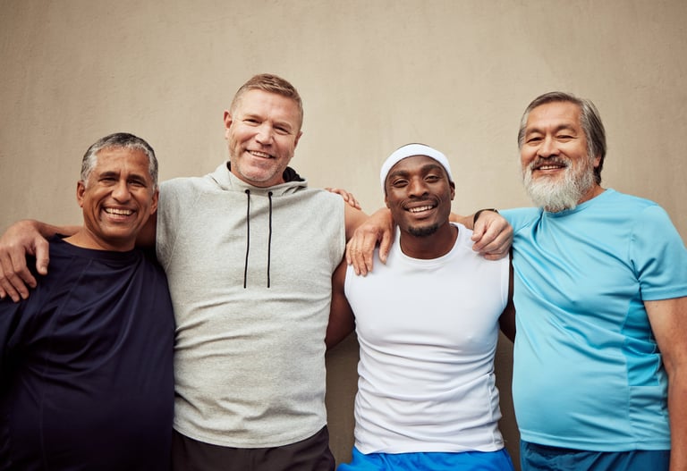 Happy diverse middle-aged men exercising and smiling together outdoors, representing fitness and wellness community for men in recovery