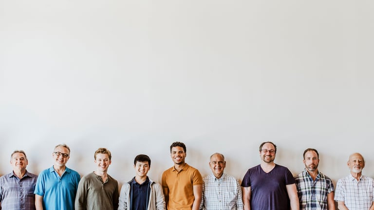 Cheerful diverse men standing together smiling, representing unity and brotherhood in recovery support