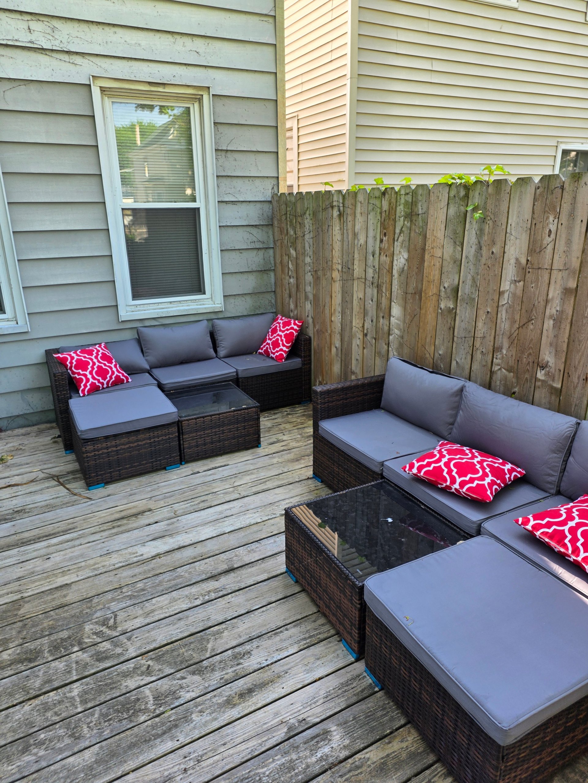 Outdoor patio deck with rattan furniture and wooden fence